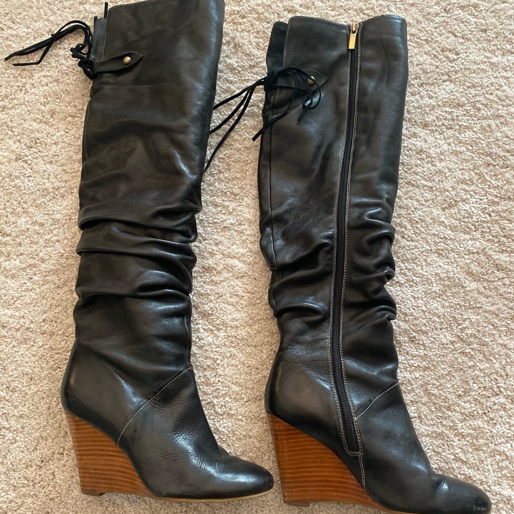 Like new black tall boots with tassels .